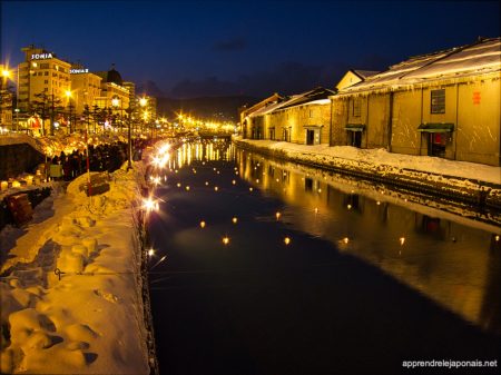 Canal d'Otaru de nuit avec bougies flottantes et entrepôts enneigés