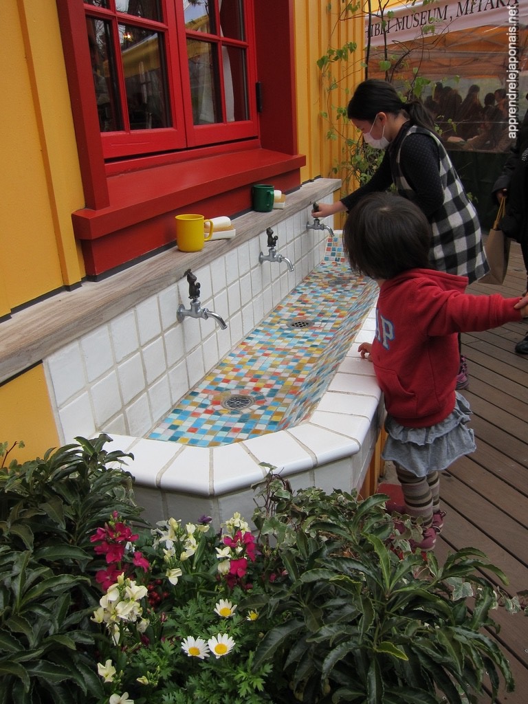 Fontaine en mosaïque colorée avec des robinets, dans la cour du musée Ghibli