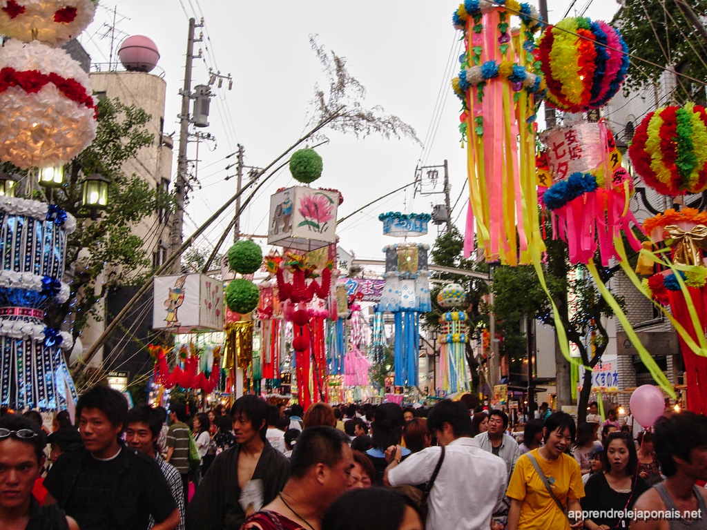 Rue bondée décorée de grandes boules et banderoles colorées pour la fête de Tanabata