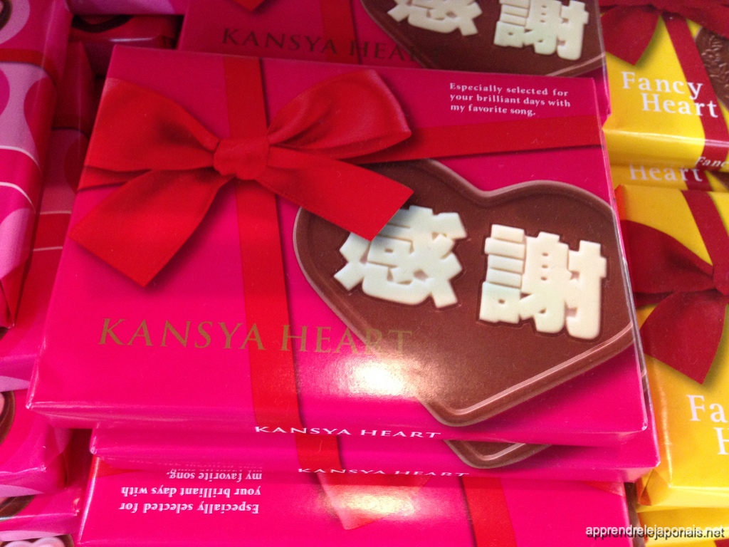 Boîte de chocolats rose en forme de cœur portant les kanji 感謝