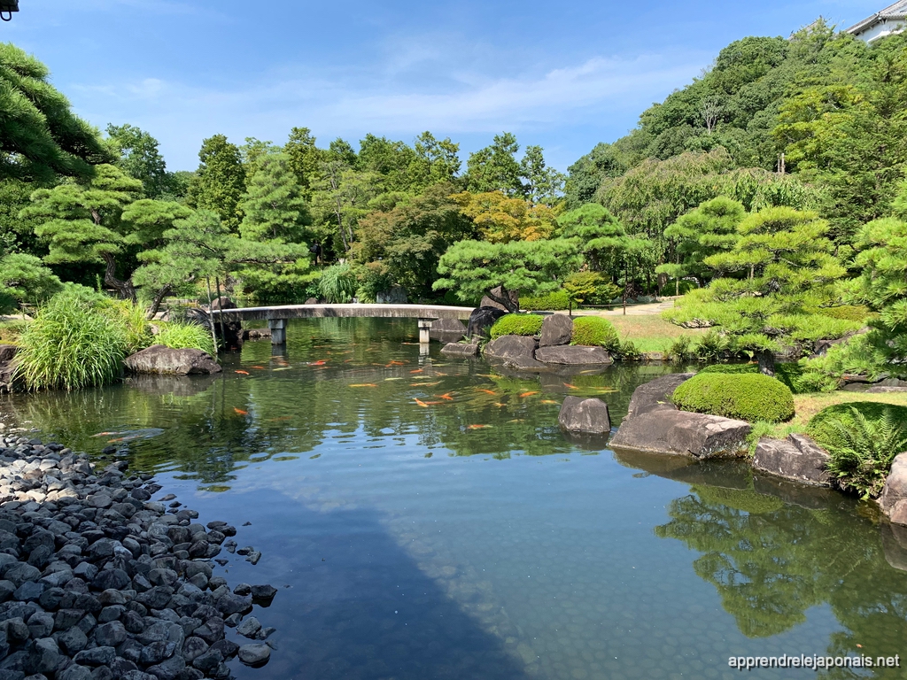 Étang avec des carpes et petit pont dans le jardin Kōko-en à Himeji